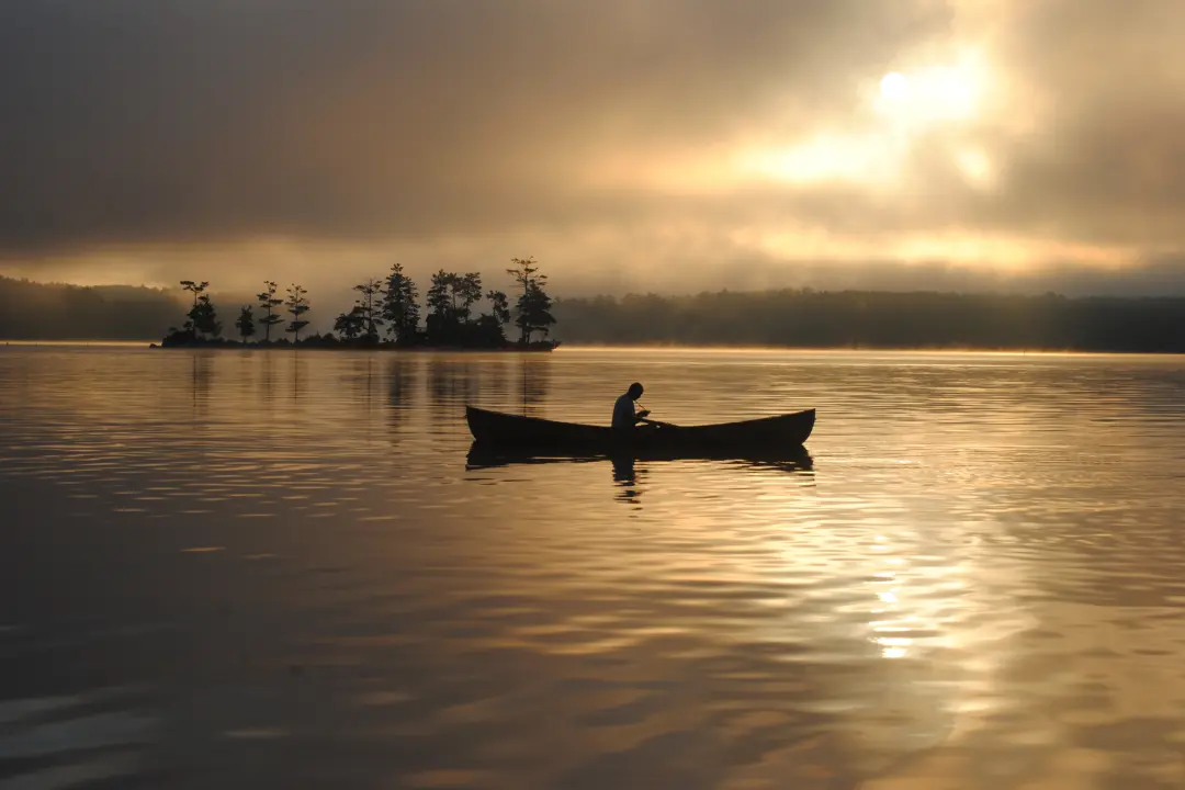 A still lake with a solitary boat floating peacefully, symbolizing self-reflection, emotional independence, and the journey of self-love