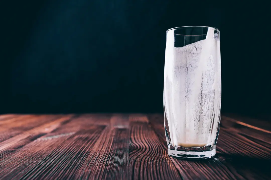 An empty glass of milk on the kitchen table, capturing a late-night conversation between siblings about change, nostalgia, and growing up